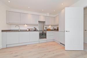 eine Küche mit weißen Schränken und Holzböden in der Unterkunft No 3 Central Chambers in Stratford-upon-Avon