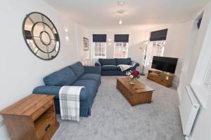 a living room with a blue couch and a tv at No 3 Central Chambers in Stratford-upon-Avon