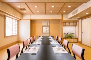 een grote vergaderzaal met een lange tafel en stoelen bij Kokusai 21 International Hotel in Nagano