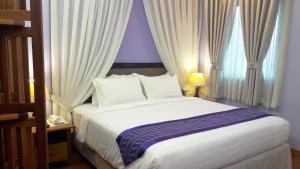 A bed or beds in a room at Grand Laurel Hotel