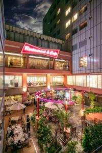 un edificio con mesas y sillas delante de él en Kokusai 21 International Hotel en Nagano