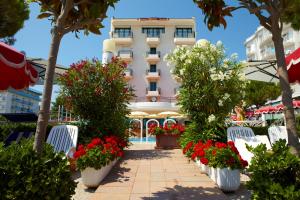 un hôtel avec des fleurs devant un bâtiment dans l'établissement Ruhl Beach Hotel & Suites, à Lido di Jesolo