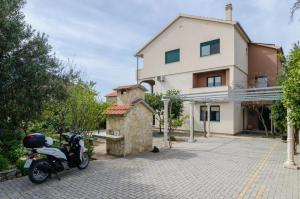 una motocicleta estacionada frente a una casa en Apartments Leo, en Orebić