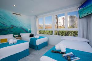 マラガにあるCasual del Mar Málagaのベッド2台と水族館が備わるホテルルームです。