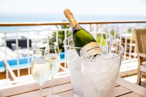 a bottle of champagne in a bucket of ice and glasses at Compass House Boutique Hotel - Adults Only in Cape Town