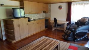 cocina con mesa y escritorio con TV en Ferienwohnung Eisenring in idyllischer Umgebung, en Gähwil