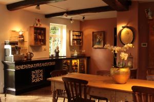 a dining room with a table with chairs and a kitchen at Boutique Hotel Bonjour in Gronsveld