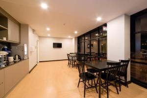 una cucina e una sala da pranzo con tavoli e sedie di Z Sleep Hotel a Hat Yai