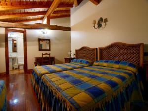a bedroom with a bed with a blue and yellow blanket at Casa Rural Endeitxe in Ereño