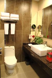 a bathroom with a toilet and a sink at Hotel Las Cascadas in San Pedro Sula