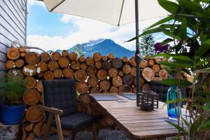 einen Holztisch mit zwei Stühlen und einem Sonnenschirm in der Unterkunft Zugspitzloft in Ehrwald