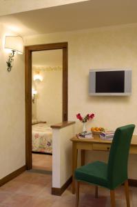 a room with a desk and a television on a wall at Hotel Santa Maria in Rome
