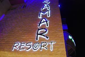 卜舍里的住宿－Samar Resort Aparthotel，建筑物一侧的 ⁇ 虹灯标志