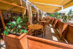 an outdoor patio with tables and chairs and potted plants at Hotel Lomsia in Akhaltsikhe