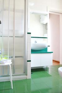 baño con suelo verde y lavabo blanco en Appartamento da Andrea, en Alcamo