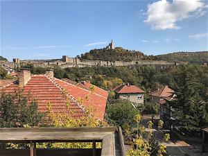 Blick auf eine Stadt mit Dächern und ein Schloss in der Unterkunft Penthouse Tsarevets in Weliko Tarnowo