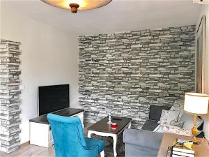 a living room with a brick accent wall at Penthouse Tsarevets in Veliko Tŭrnovo