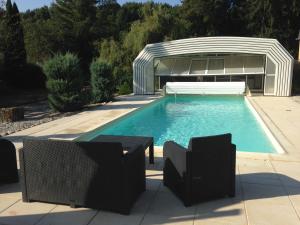 a swimming pool with a pavilion and a swimming poolvisor at Logis Hôtel DOMAINE du MOULIN in Saint-Avold