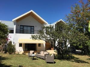 a white house with a tree in front of it at Villa Honeysuckle Luxury 4 Bedroom in Stellenbosch