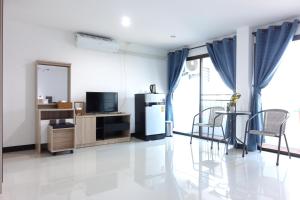 a living room with a refrigerator and some chairs at Rinn Boutique House in Chiang Mai
