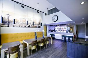 a restaurant with tables and chairs and a clock on the wall at City Hotel Amsterdam in Amsterdam