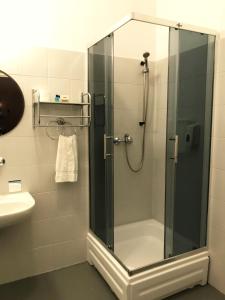 オストルフ・ビエルコポルスキにあるHotel Granadaのバスルーム(ガラスドア付きのシャワー付)