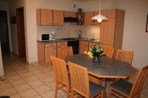 a kitchen with a table and chairs and a kitchen with a counter at R&eacute;sidence V&eacute;nus in Eguisheim