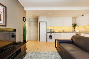 a living room with a couch and a kitchen at The Odyssee 409 in Cape Town