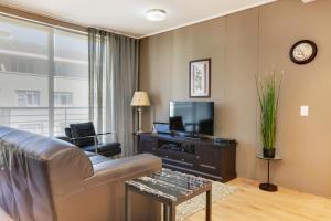 a living room with a couch and a tv at The Odyssee 409 in Cape Town