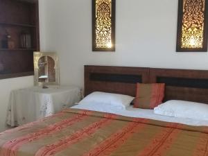a bedroom with two beds and a table at dar wassim el ghali in Rabat