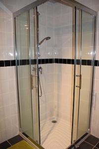 een douche met een glazen deur in de badkamer bij Gîte très lumineux in Vernines