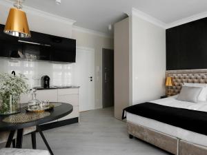 グダニスクにあるLavoo Boutique Apartmentsのベッドルーム1室(ベッド1台、テーブル付)、キッチン