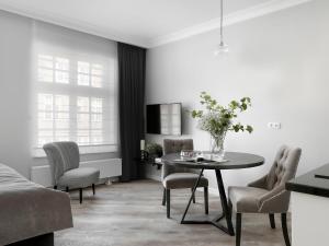 sala de estar con mesa y sillas en Lavoo Boutique Apartments, en Gdansk