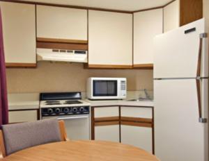 a kitchen with a table and a white refrigerator at Econo Lodge Franklin in Franklin