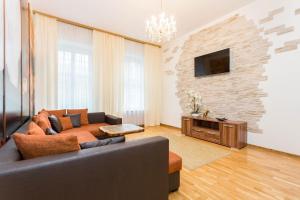 ein Wohnzimmer mit einem Sofa und einem TV in der Unterkunft Orchid Apartment Old Town in Tallinn