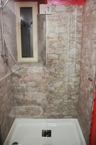 a bathroom with a shower with a stone wall at La Tana Delle Lepri in Morolo +51 photos