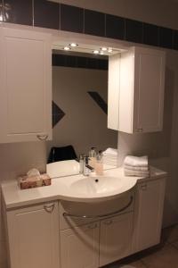 ein Badezimmer mit einem weißen Waschbecken und einem Spiegel in der Unterkunft Appartement Celia in Wittisheim