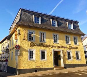 a yellow building on the corner of a street at Hotel zur goldenen Sonne in Usingen