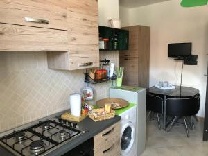 a kitchen with a stove and a washer and dryer at Casa Mojito in Sassari