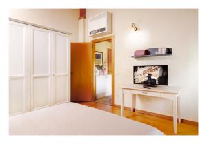 a room with a bed and a desk with a tv at Al Gallo Nero in Borgoricco