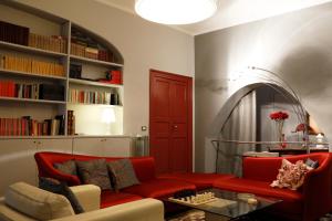 ジェノヴァにあるB&B FlairHouseのリビングルーム(赤いソファ、テーブル付)