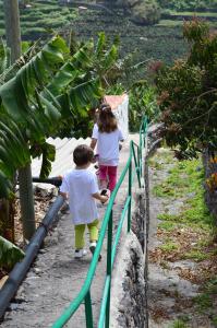 a boy and girl walking down a walkway next to a fence at La Cuadra in Hermigua