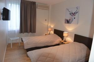 Habitación de hotel con 2 camas y ventana en Pyrenees Resort en Argelès-Gazost