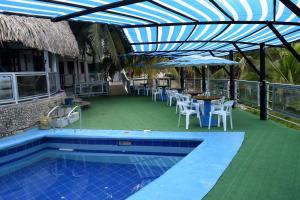 a patio with a table and chairs and a pool at Crucero Hotel in Arboletes