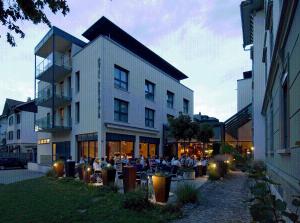 un groupe de personnes assis à l'extérieur d'un bâtiment dans l'établissement Hotel Berchtold, à Burgdorf