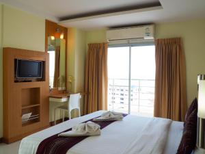 Habitación de hotel con cama y TV en Eastiny Seven Hotel, en Pattaya central