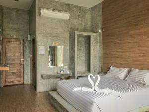 een slaapkamer met een bed met een witte zwaan erop bij Alinda Resort in Phetchaburi