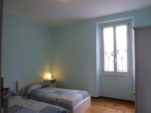 um quarto com 2 camas e uma janela em Casa Re em Gravedona