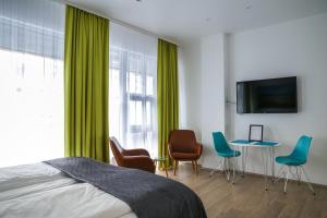 a bedroom with green curtains and a table and chairs at Iceland Comfort Apartments by Heimaleiga in Reykjavík