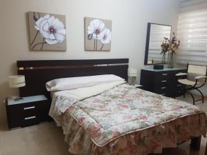 sypialnia z łóżkiem, biurkiem i 2 lampami w obiekcie Apartamento Eduardo Dato w Sewilli
